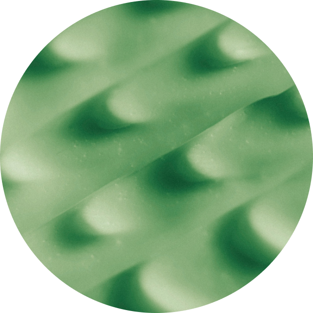 A circular close-up of a green textured material with a wavy, ribbed pattern on a white background.